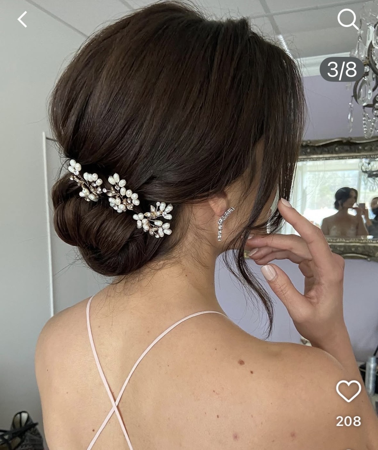 Elegant low bridal updo with pearl hairpiece
